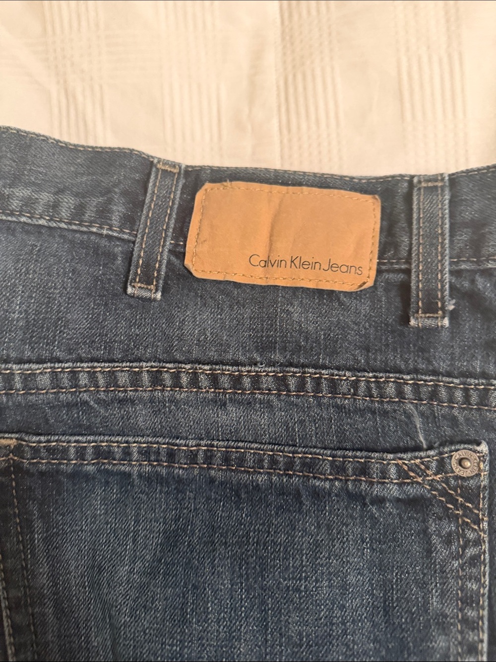 Calvin Klein Jeans indigo denim with tan leather patch